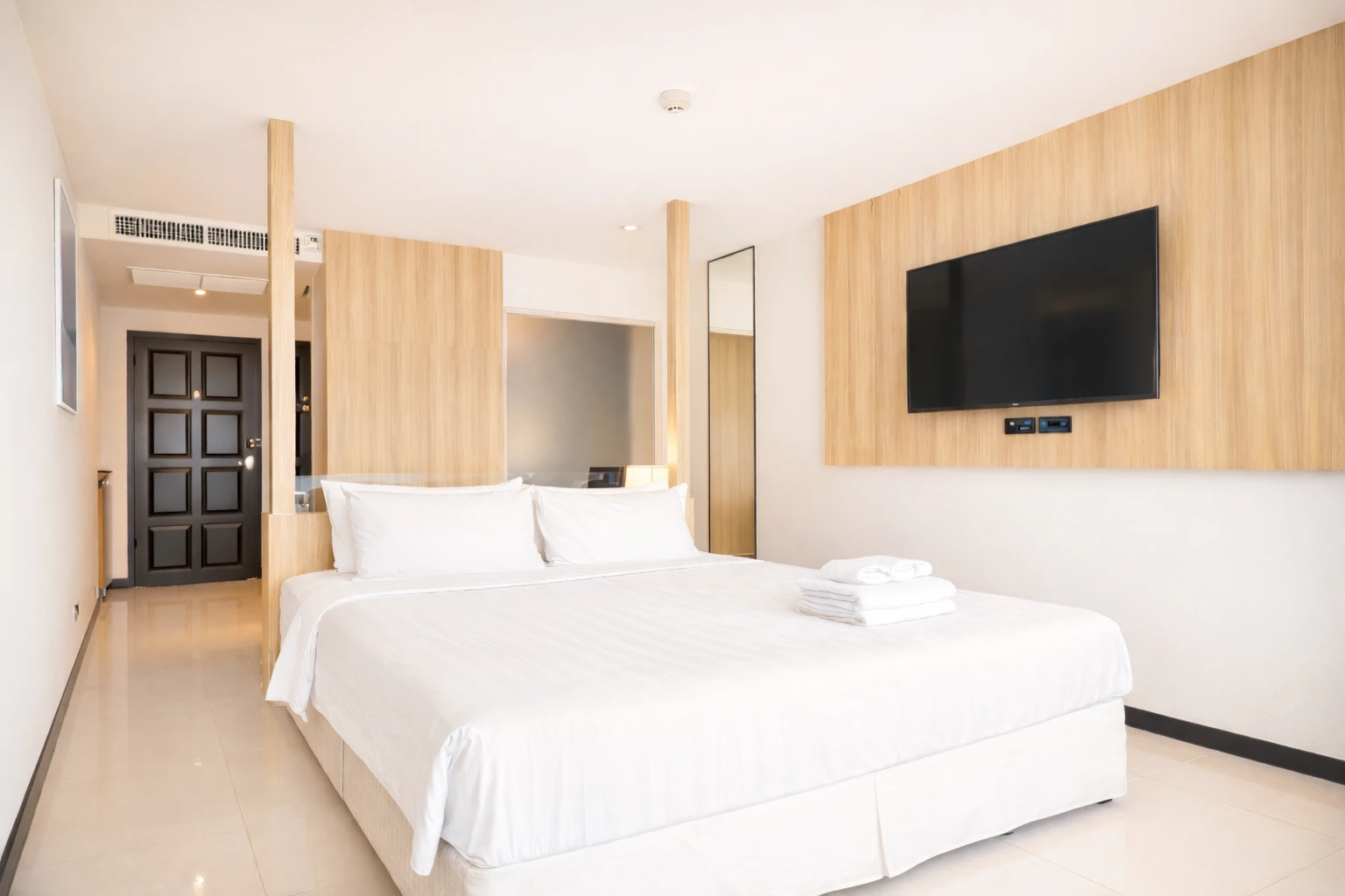 King bed with the TV wall opposite and the entrance behind