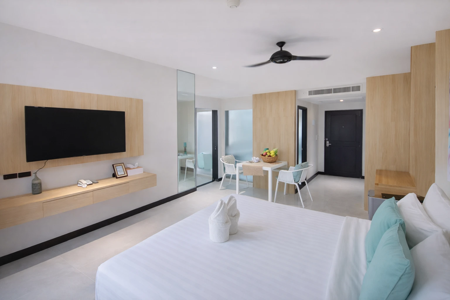 The room seen from the bed: TV wall, dining table and entrance