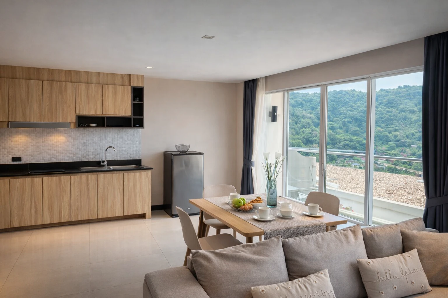The kitchen and dining table, with the balcony and the green hillside beyond